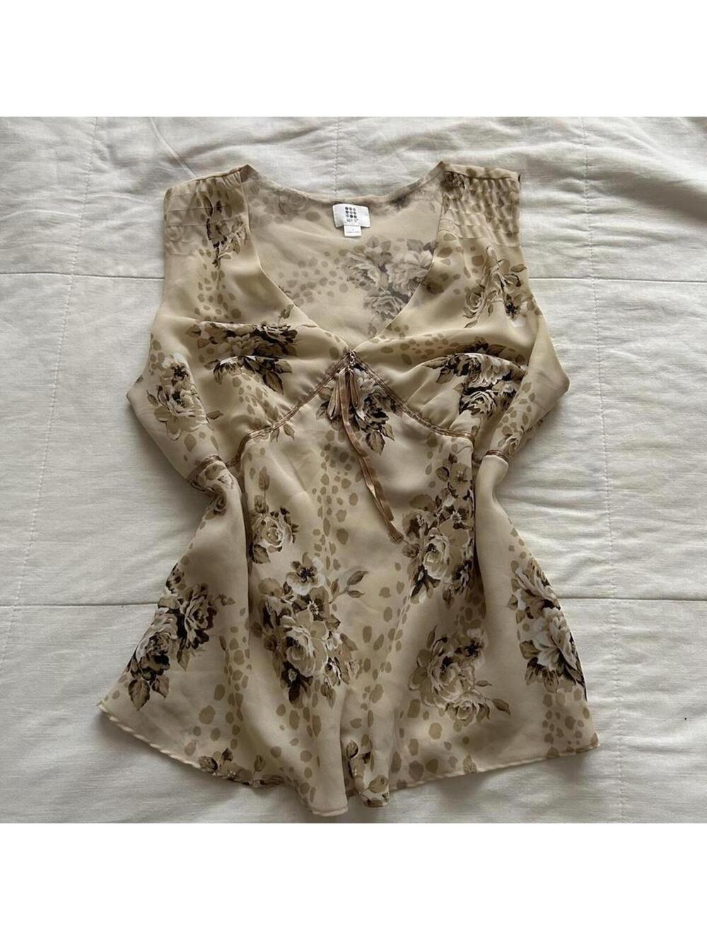 Tan floral sleeveless babydoll blouse with tie detail and side zipper